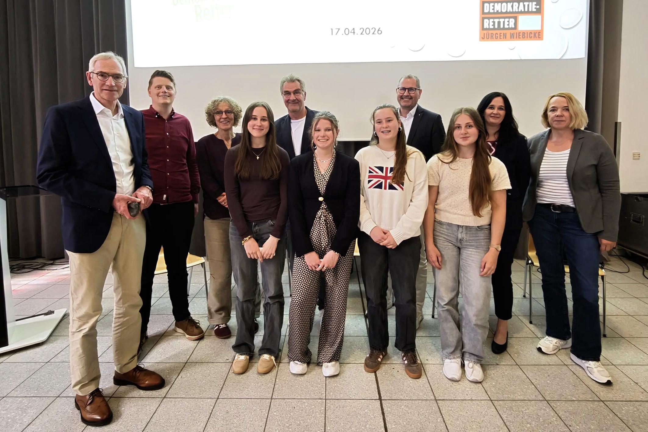 Bildunterschrift:  Demokratie im Dialog: Ines Philipen, Elisabeth Anlauf, Nila Küppers und Paula Philipen, Schülerinnen der Jahrgangsstufe 10 des Gymnasiums St. Ursula, gestalteten gemeinsam mit Autor Jürgen Wiebicke eine lebhafte Diskussion über gesellschaftliche Verantwortung und demokratische Werte. Auf dem Bild (v. l.): Schulleiter Jürgen Pallaske, Lehrer Sebastian Tschakert, Mechtild Bose, Jürgen Wiebicke, Ulrich Paus, Judith Anlauf, Sylke Kreyes vom Caritasverband sowie die vier moderierenden Schülerinnen.