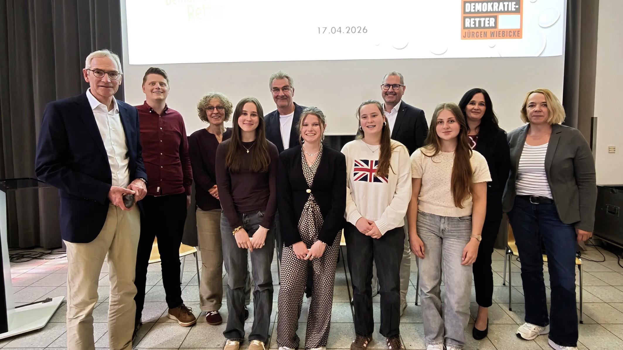 Bildunterschrift:  Demokratie im Dialog: Ines Philipen, Elisabeth Anlauf, Nila Küppers und Paula Philipen, Schülerinnen der Jahrgangsstufe 10 des Gymnasiums St. Ursula, gestalteten gemeinsam mit Autor Jürgen Wiebicke eine lebhafte Diskussion über gesellschaftliche Verantwortung und demokratische Werte. Auf dem Bild (v. l.): Schulleiter Jürgen Pallaske, Lehrer Sebastian Tschakert, Mechtild Bose, Jürgen Wiebicke, Ulrich Paus, Judith Anlauf, Sylke Kreyes vom Caritasverband sowie die vier moderierenden Schülerinnen.