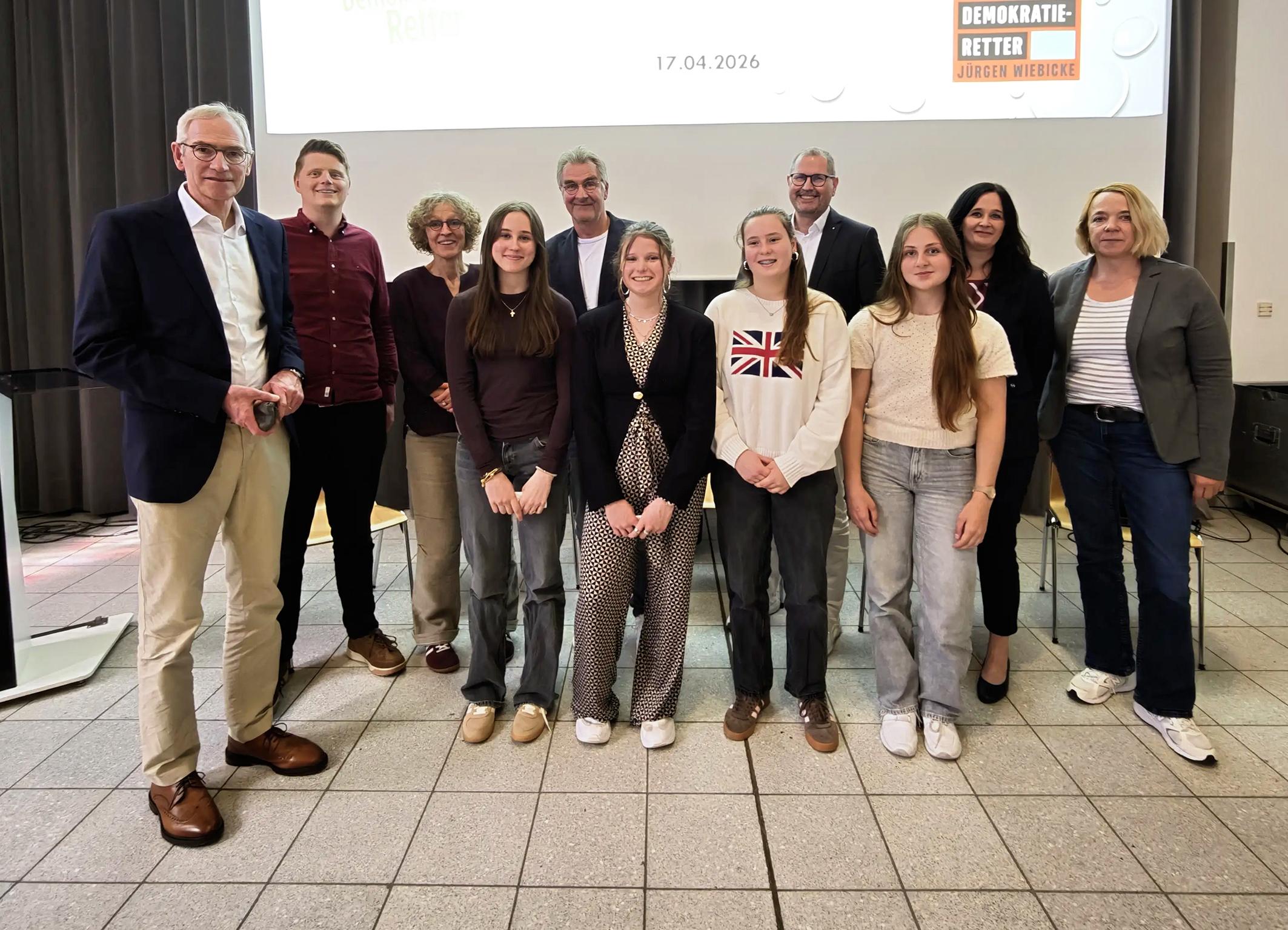 Bildunterschrift:  Demokratie im Dialog: Ines Philipen, Elisabeth Anlauf, Nila Küppers und Paula Philipen, Schülerinnen der Jahrgangsstufe 10 des Gymnasiums St. Ursula, gestalteten gemeinsam mit Autor Jürgen Wiebicke eine lebhafte Diskussion über gesellschaftliche Verantwortung und demokratische Werte. Auf dem Bild (v. l.): Schulleiter Jürgen Pallaske, Lehrer Sebastian Tschakert, Mechtild Bose, Jürgen Wiebicke, Ulrich Paus, Judith Anlauf, Sylke Kreyes vom Caritasverband sowie die vier moderierenden Schülerinnen.