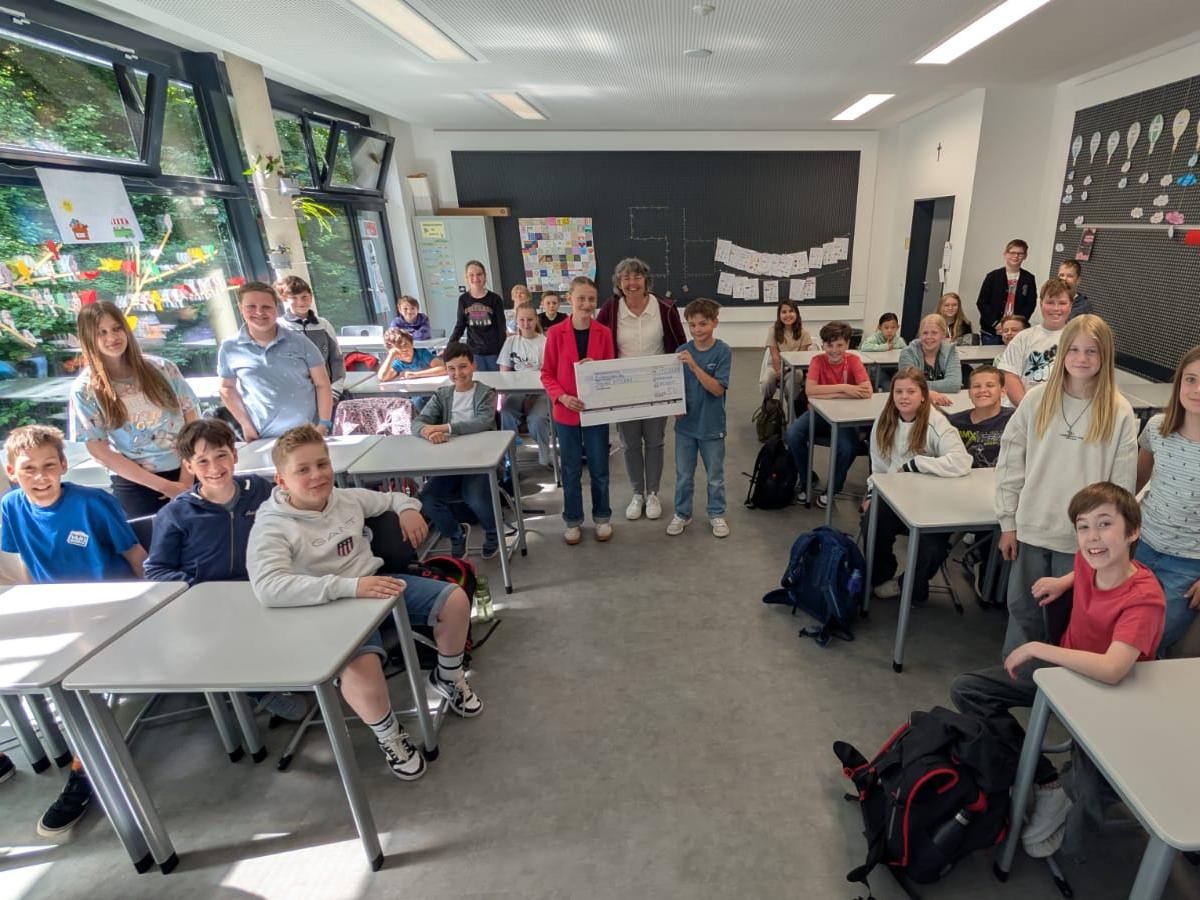 Strahlende Gesichter bei der Scheckübergabe: Klasse 5b des Gymnasiums Sankt Ursula sammelt 1.000 Euro für das Misereor-Schulprojekt Vozama (c) Bischöfliches Gymnasium St. Ursula Geilenkirchen (Chris Nettelrodt)